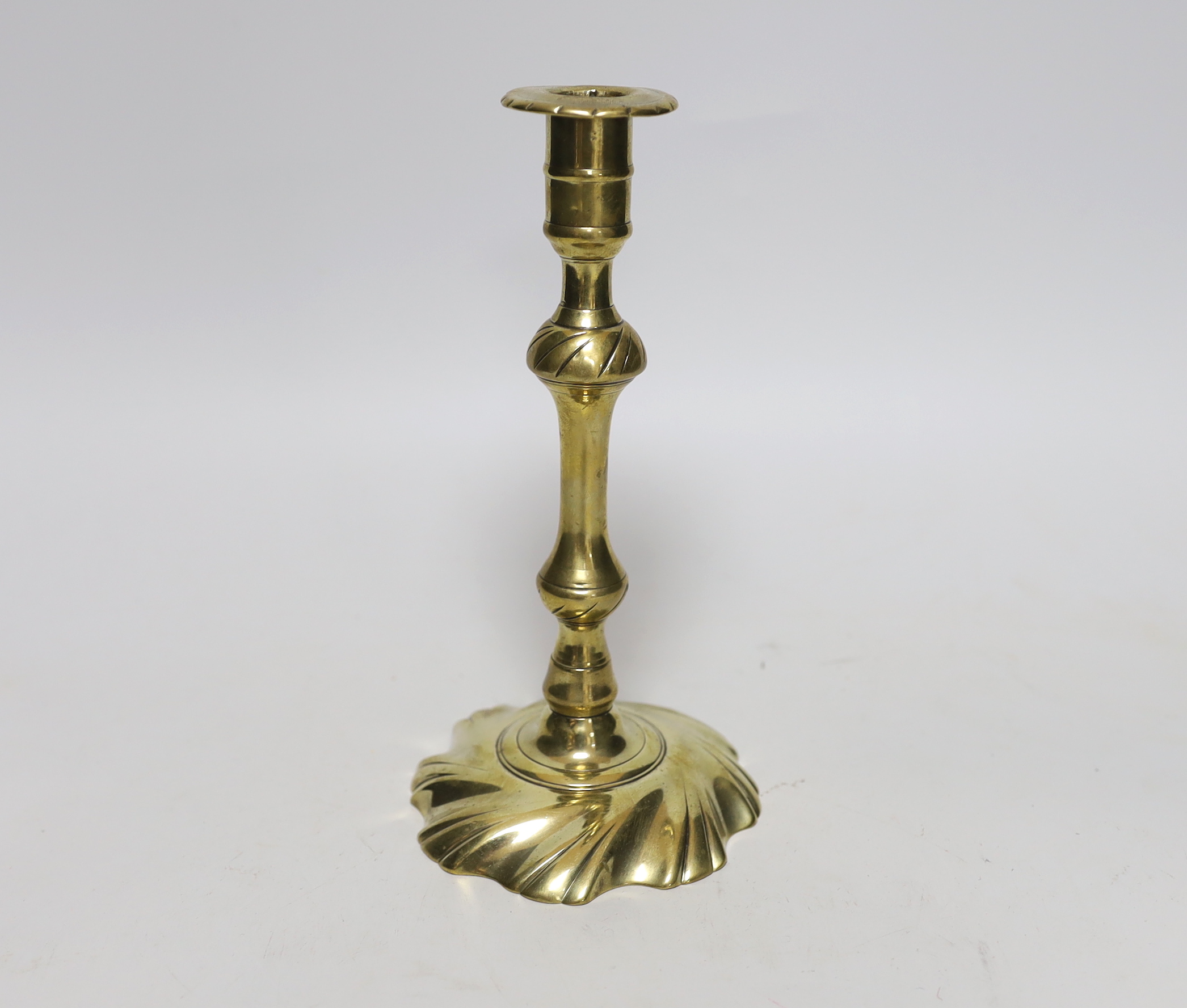 A mid 18th century swirl base brass candlestick, 21cm